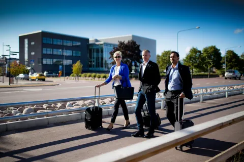 Tre affärsresenärer som håller i sina resväskor