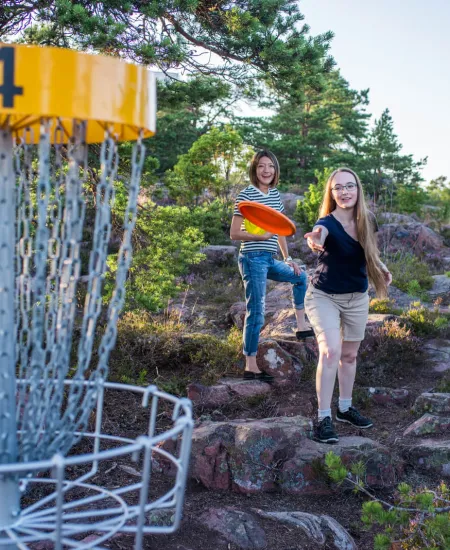 Två personer som spelar discgolf