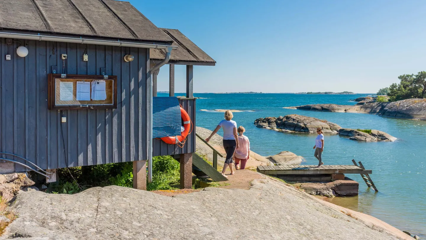 Familj vid havet och klippor på Åland – boende nära natur, hav och skärgård