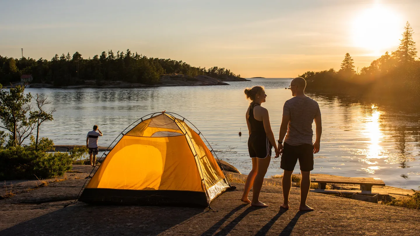Telttailua meren rannalla Ahvenanmaan saaristossa auringonlaskussa