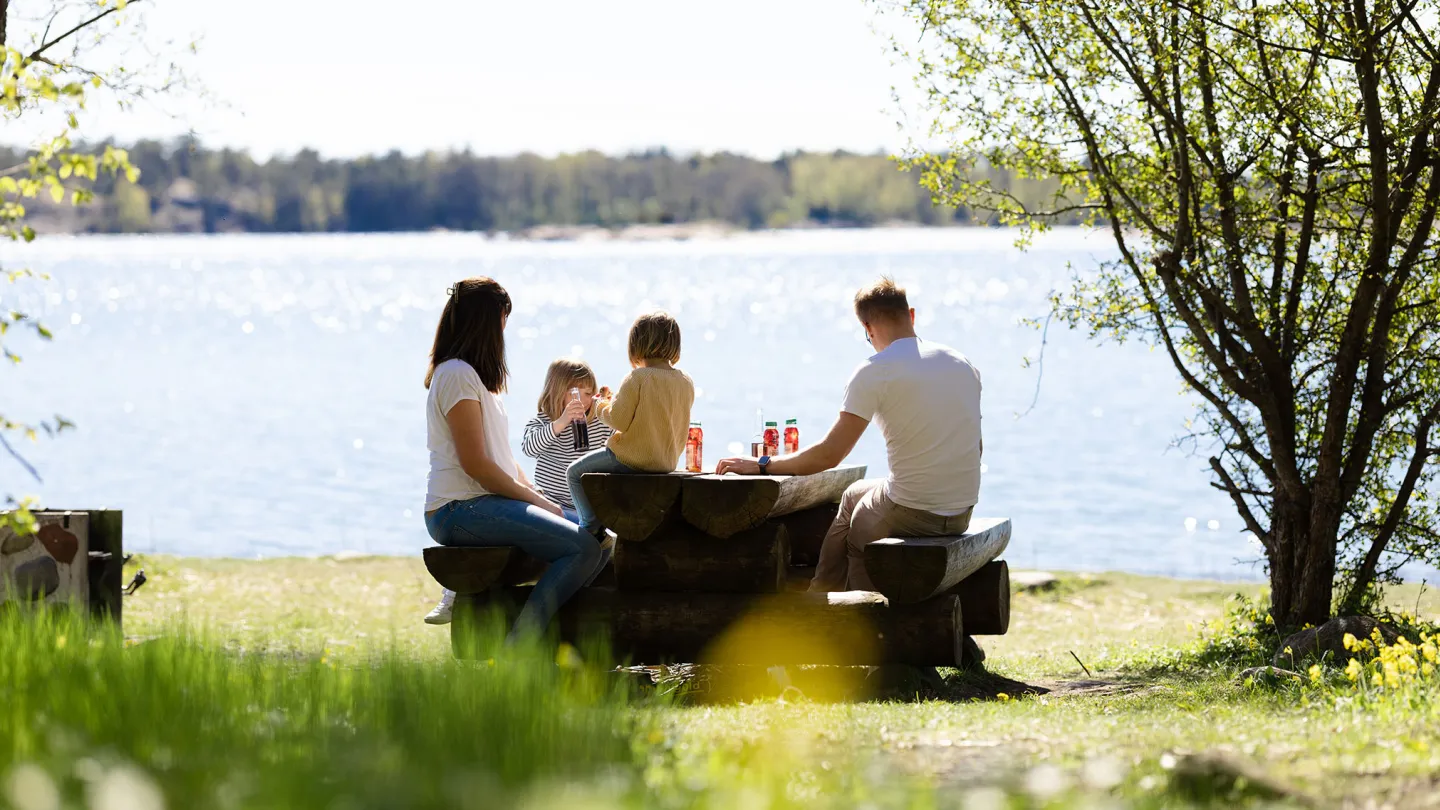 Familj vid havet i Ålands skärgård under en solig vårdag