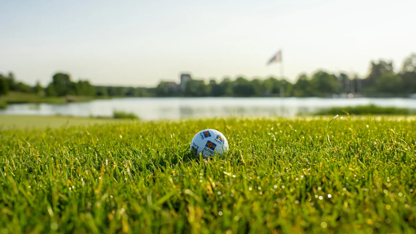 Golfboll på green vid havet på Åland inför en dag med golfpaket och spel på natursköna banor