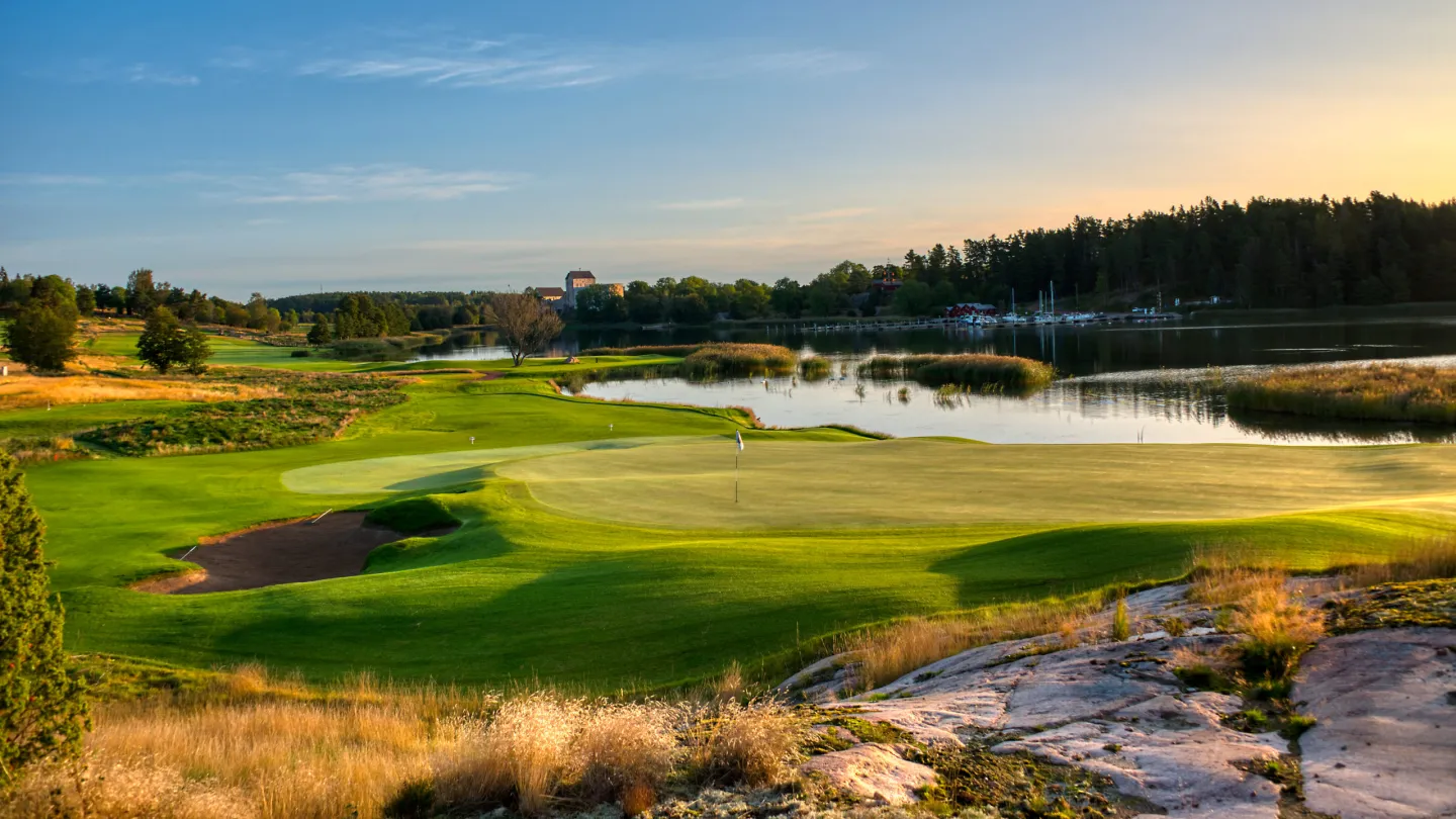 Green vid Kungsbanan på Ålands Golfklubb med utsikt över vattnet och Kastelholms slott i bakgrunden